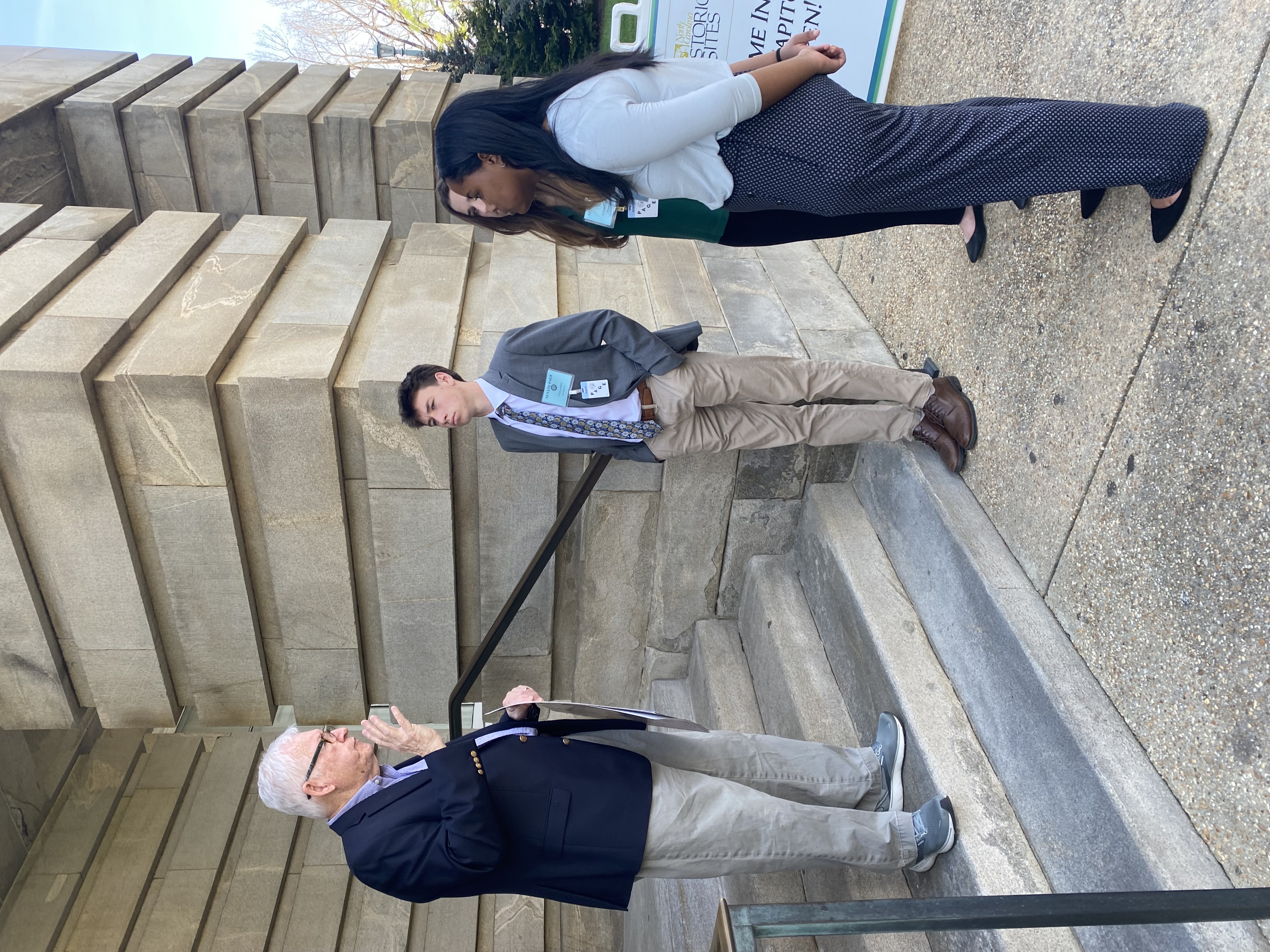 Senate Pages talking to a Senator outside the state capitol.